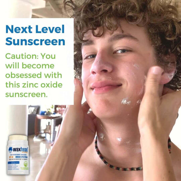 A young boy applying Reef Safe Zinc Sunscreen Stick on his face, showcasing its smooth application and effectiveness.