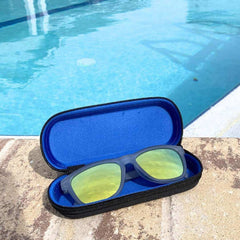 Yellow Sunglasses Polarized in a blue case by a swimming pool, showcasing their vibrant color and outdoor utility.