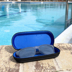 Silver Polarized Sunglasses in a protective case near a swimming pool, showcasing style and sustainability.