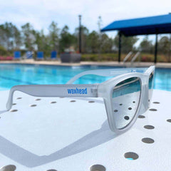 Silver Polarized Sunglasses by Waxhead, placed near a poolside, showcasing stylish design and UV protection.