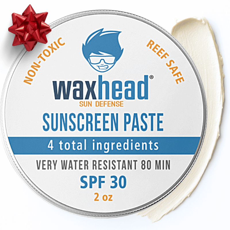 Waxhead sunscreen paste container with a red bow on a white background